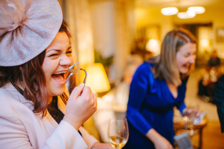 Guests at a Homewood House Hotel in Bath wedding laughing at magic tricks