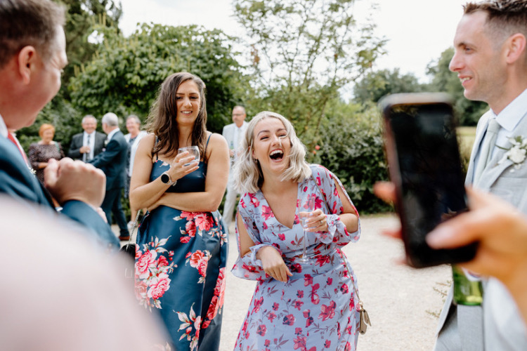 A smiling guest at wedding venue Elmore Court enjoying card tricks