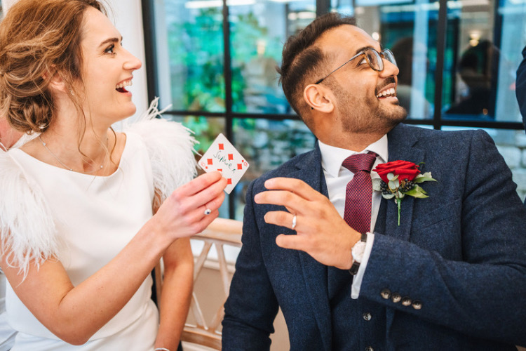 Newlyweds Sophie and Ash enjoying a special romantic card trick at the wedding venue The Pear Tree at Purton