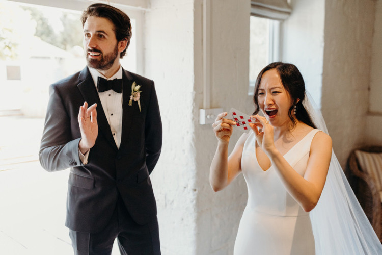 Bride and Groom enjoying close up magic tricks at Lapstone Barn wedding venue in the Cotswolds